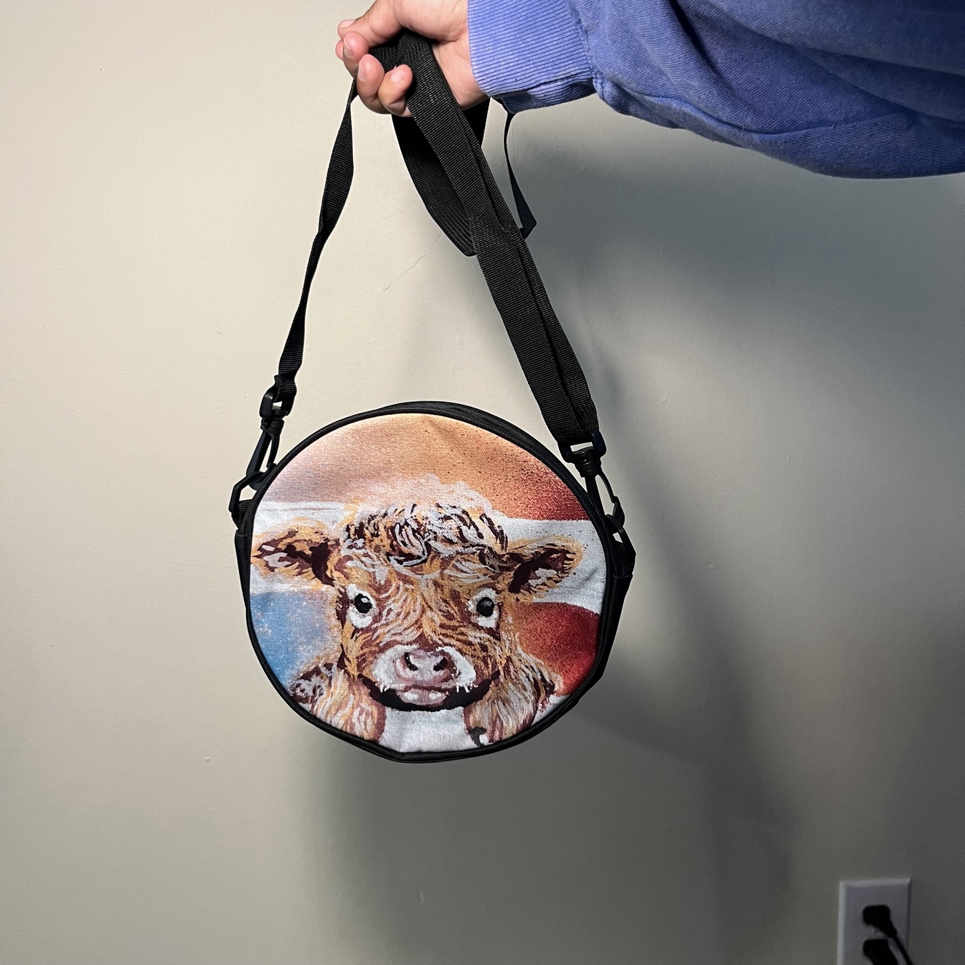 Baby Highland Cow — Round crossbody bag, photographed by the artist